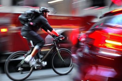 cyclist riding between lanes of traffic
