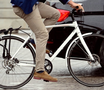 man on a bicycle next to a car
