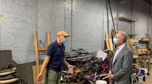 man next to Recycled Bikes