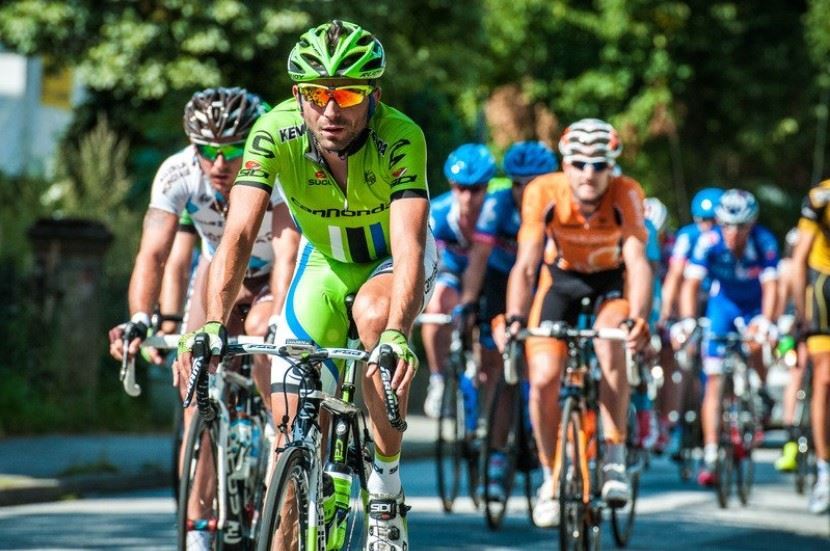 group of cyclists wearing safety gear while biking