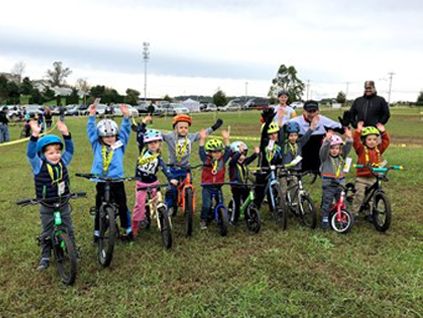 Hands in the air finish for youngest cyclists at West Chester Cross Class in 2019 posing with cross Legend Bob Reuther.
